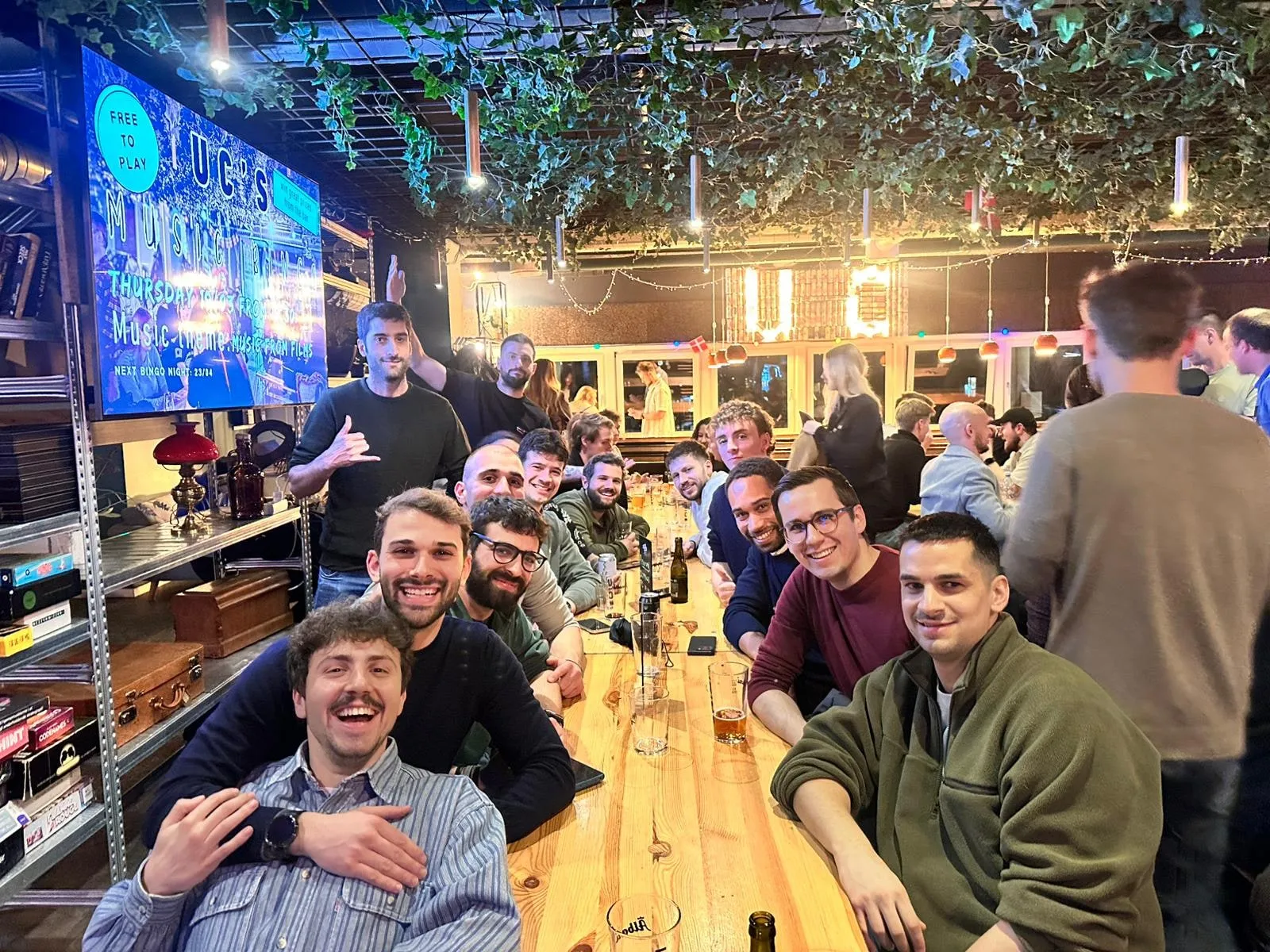 Club members smile and laugh around a long table at a bar